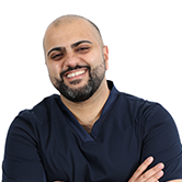 Image is of Haider. He is smiling with his arms folded.