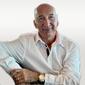 image is of Phil. He is wearing a white shirt and big watch standing in a comfortable position.